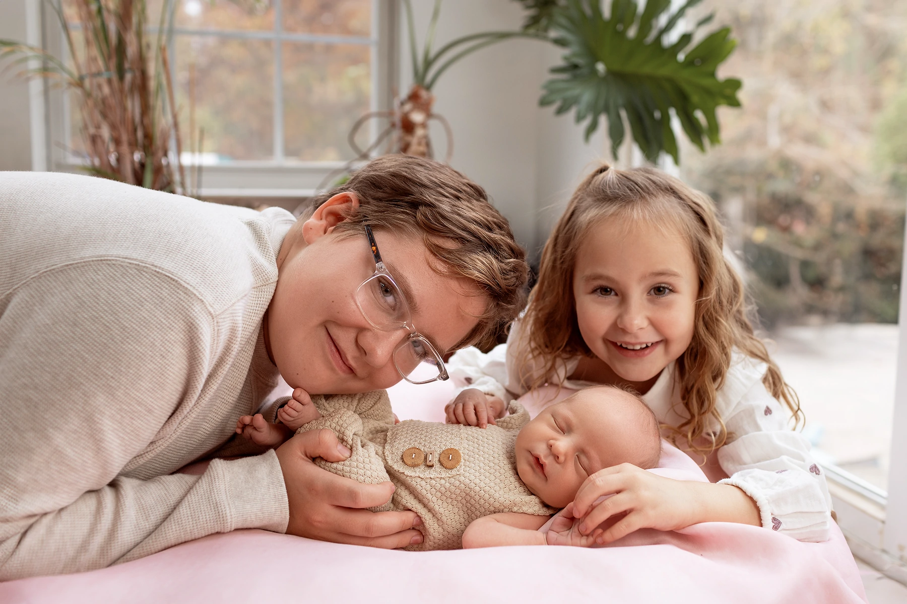 In-home newborn photography session with dad, sister, and baby on the bed, shot by Tender Beginning