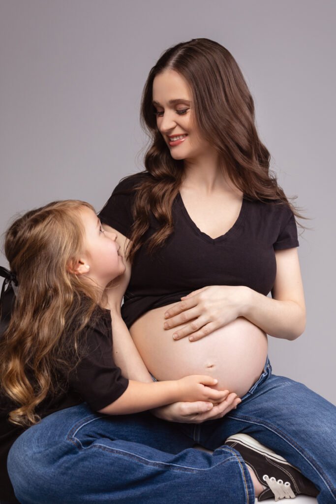 Mother and daughter maternity portrait, daughter kissing the belly, shot by Tender Beginning
